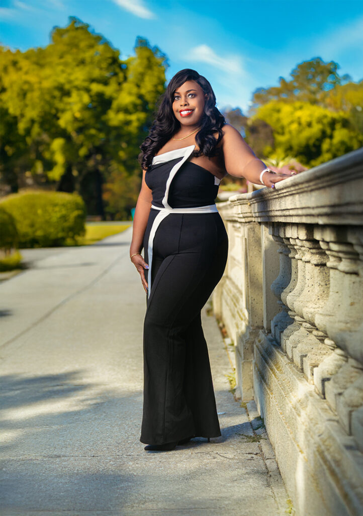 Smiling woman in black gown by stone balustrade